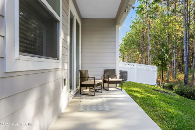 a view of a patio with table and chairs and floor to ceiling window