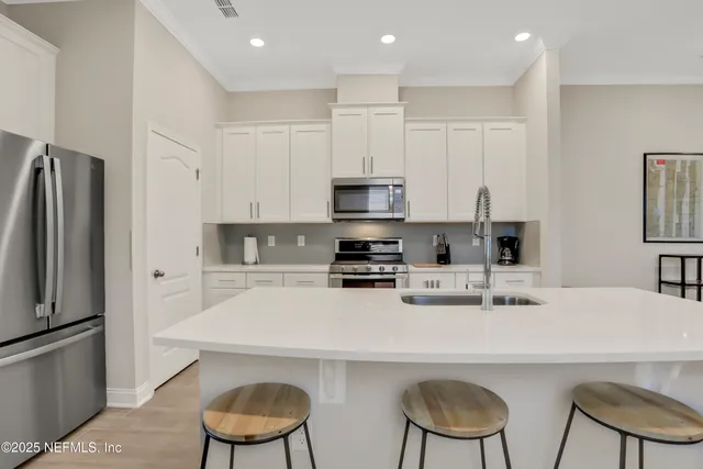a kitchen with stainless steel appliances a stove a sink and a refrigerator
