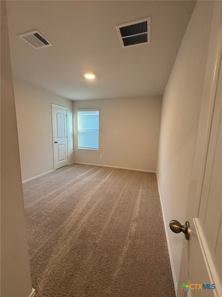 208 Ida Loop Seguin, TX 78155 - Photo 10 of 16 an empty room with wooden floor and windows