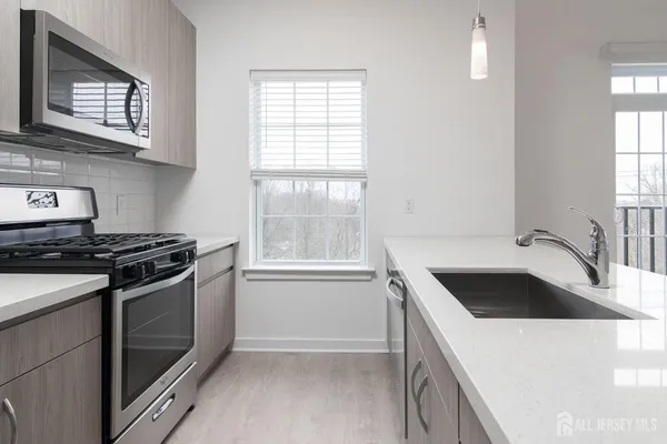 a kitchen with granite countertop a stove and a sink