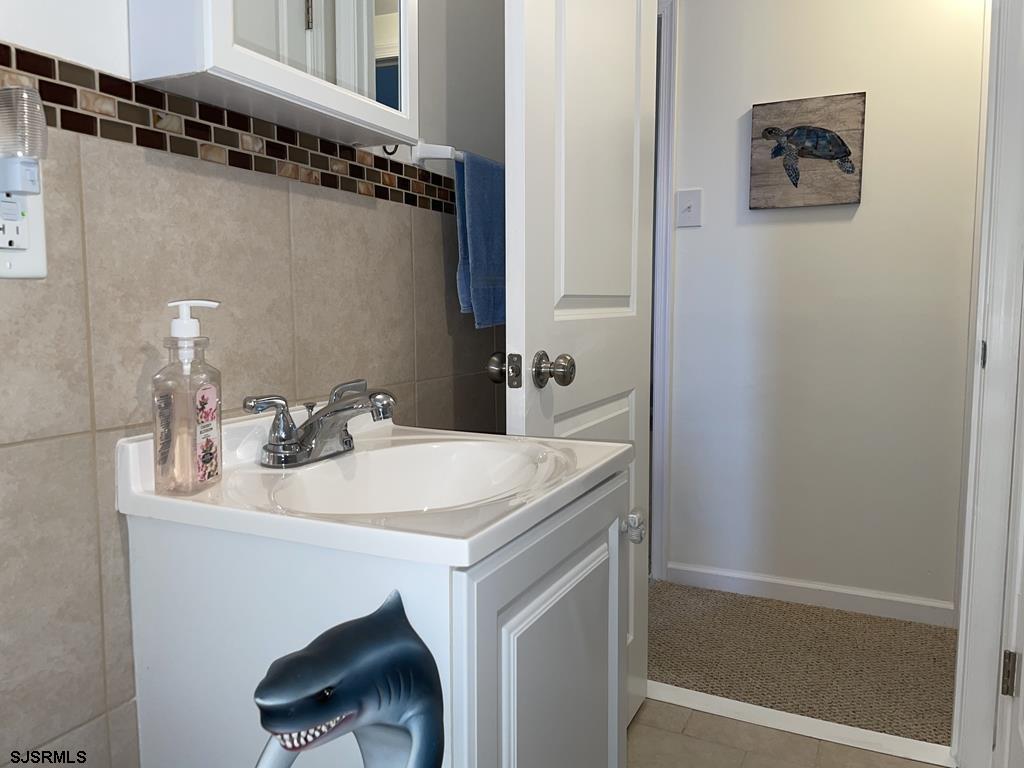 111 10th Street South, Unit B Brigantine, NJ 08203 - Photo 11 of 19 a bathroom with a sink and a mirror
