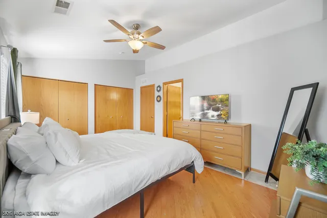 a bedroom with a bed and a large mirror on the dresser