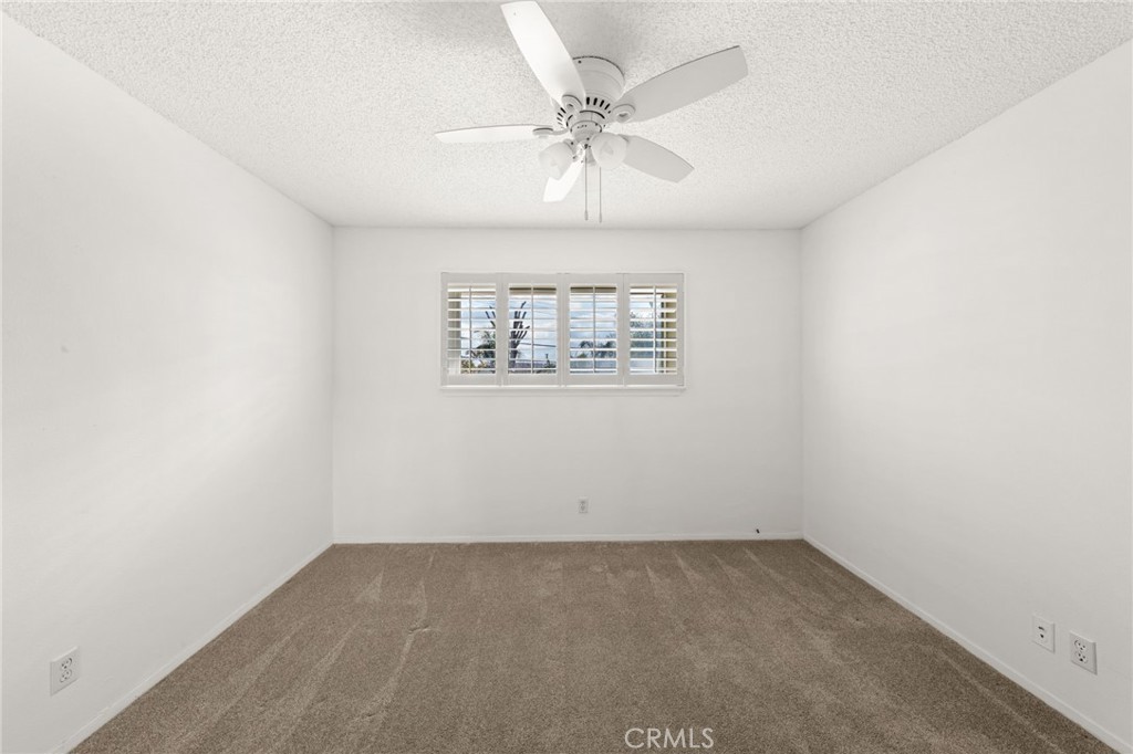 8242 Baldwin Circle Buena Park, CA 90621 - Photo 24 of 44 an empty room with a chandelier fan and windows
