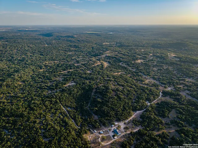 an aerial view of house with yard and mountain view in back