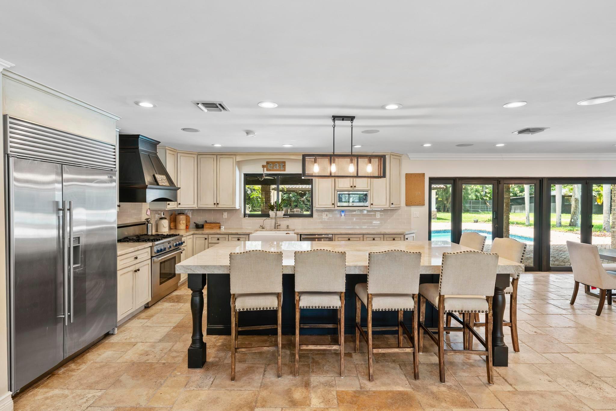 14701 Southwest 63rd Street Southwest Ranches, FL 33330 - Photo 16 of 50 a large kitchen with a table and chairs