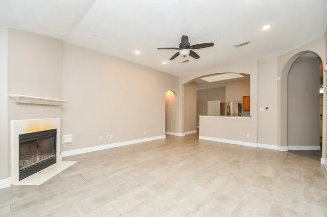 an empty room with windows and fireplace