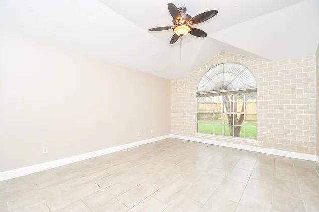 an empty room with a window and a ceiling fan