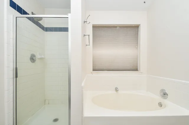 an empty room with chandelier fan and windows