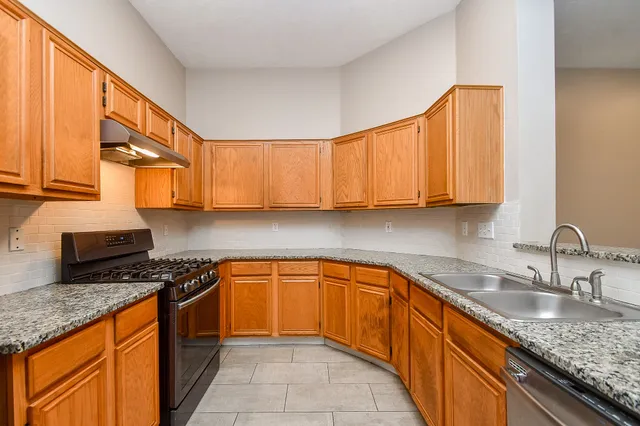 a kitchen with stainless steel appliances granite countertop refrigerator sink and cabinets