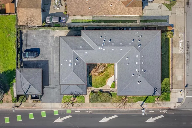 an aerial view of a multi story building with yard