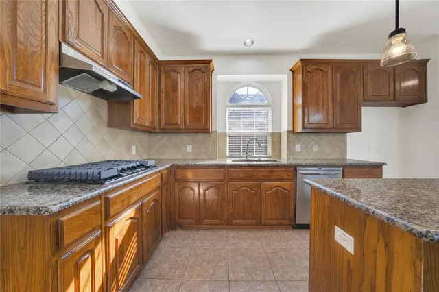a kitchen with stainless steel appliances granite countertop a sink stove and cabinets
