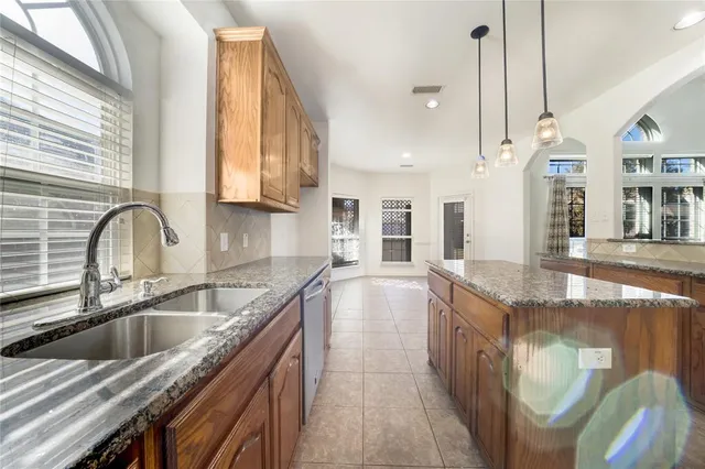 a kitchen with stainless steel appliances granite countertop a sink a stove and a wooden floors