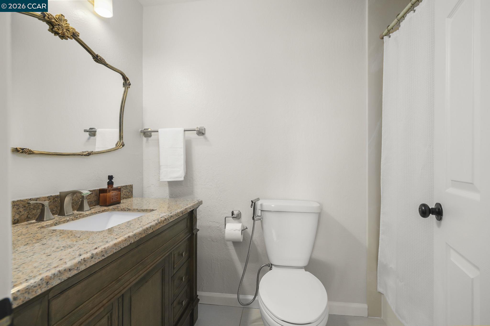 4151 Storey Lane Concord, CA 94518 - Photo 21 of 40 a bathroom with a granite countertop toilet sink and mirror
