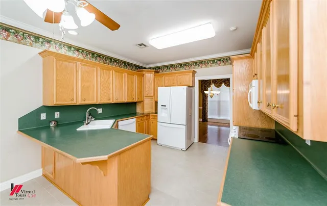 a kitchen with a refrigerator a stove and a sink with wooden floor