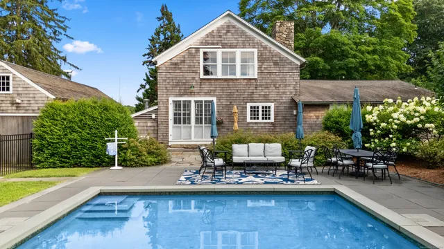 a front view of a house with swimming pool having outdoor seating
