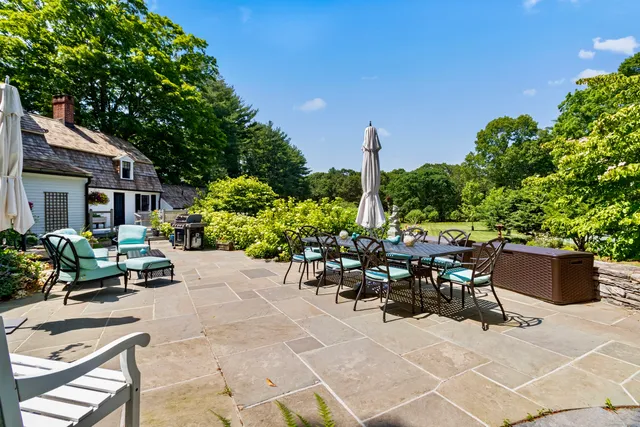 a view of a patio with furniture and a garden
