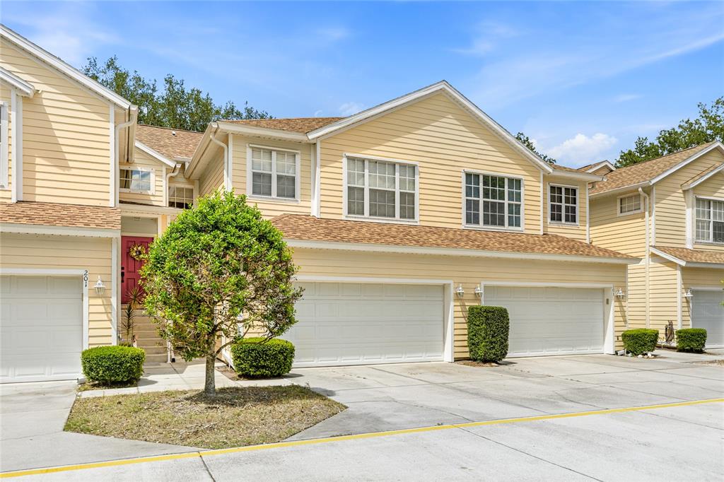 6216 Rosefinch Court, Unit 102 Lakewood Ranch, FL 34202 - Photo 1 of 45 a front view of a house with a yard and garage