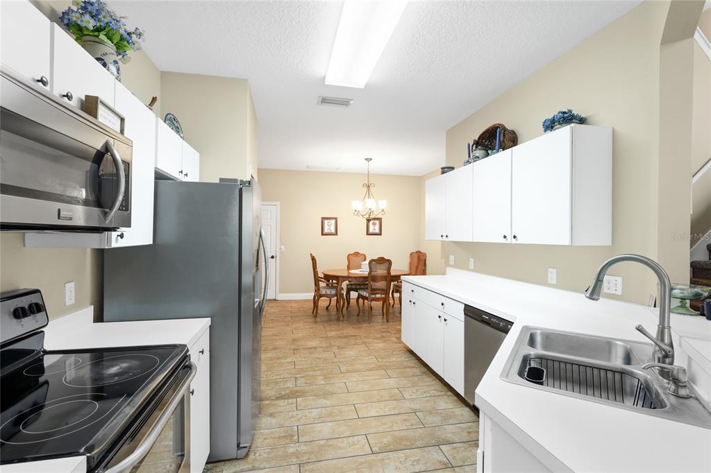 6216 Rosefinch Court, Unit 102 Lakewood Ranch, FL 34202 - Photo 12 of 45 a kitchen with stainless steel appliances granite countertop a sink a stove and microwave