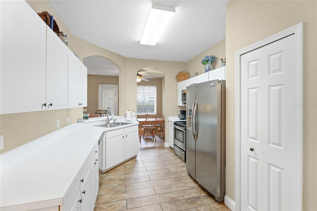 6216 Rosefinch Court, Unit 102 Lakewood Ranch, FL 34202 - Photo 13 of 45 a large kitchen with a refrigerator a sink a stove and cabinets