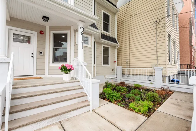 a front view of a house with potted plants
