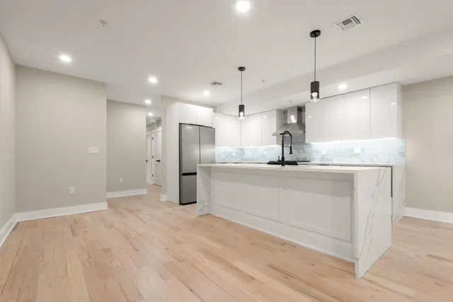 a kitchen with stainless steel appliances kitchen island a refrigerator and a sink