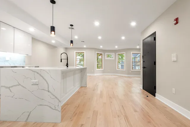 a large kitchen with kitchen island a stove a refrigerator a sink dishwasher with a dining table and chairs with wooden floor