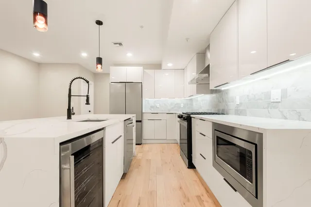 a kitchen with granite countertop a sink stainless steel appliances and cabinets