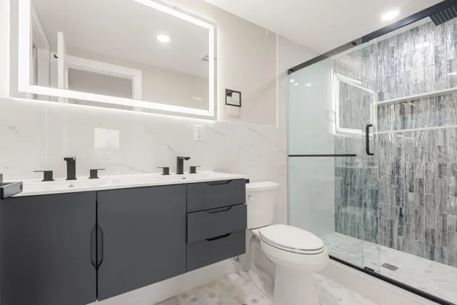 a bathroom with a sink mirror vanity and toilet