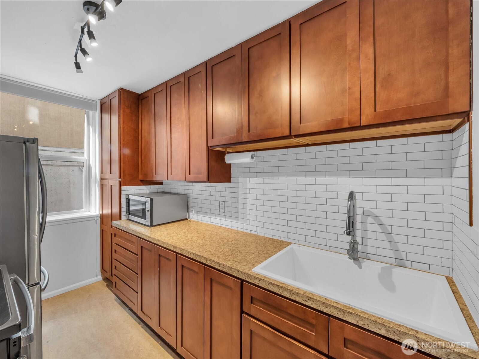 7 Harrison Street, Unit 17 Seattle, WA 98109 - Photo 8 of 20 a kitchen with a sink and cabinets