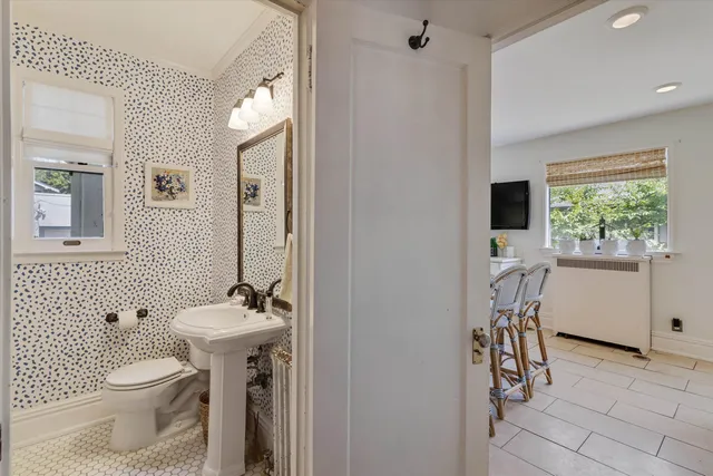 a bathroom with a toilet a sink and a mirror