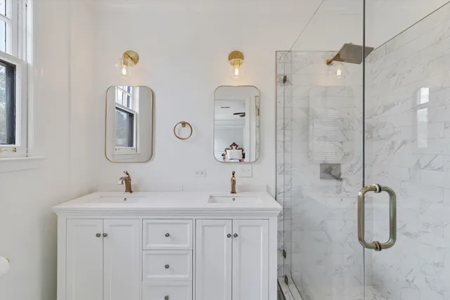 a bathroom with a double vanity sink mirror and shower