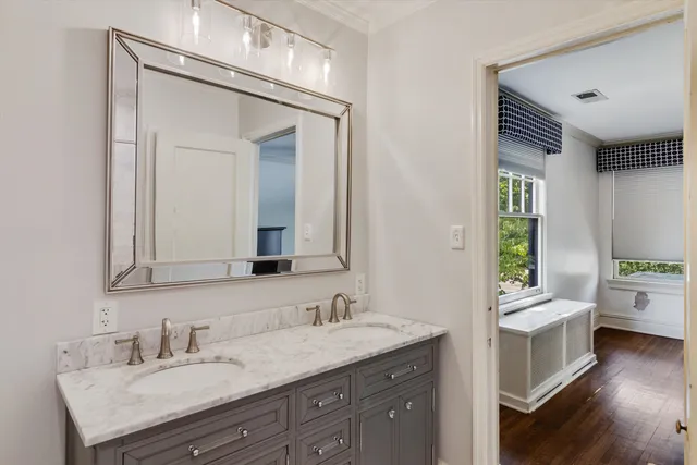 a en suite bathroom with a granite countertop sink and a mirror