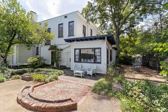 a view of a house with backyard fire pit and chairs