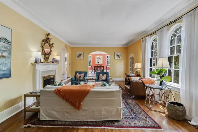 a living room with fireplace furniture and a floor to ceiling window