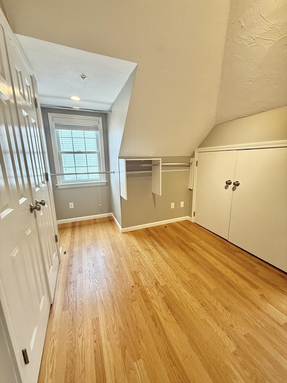 56 Eliot Street, Unit C Natick, MA 01760 - Photo 19 of 21 an empty room with wooden floor and windows