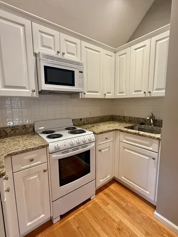 a kitchen with white cabinets stainless steel appliances and sink