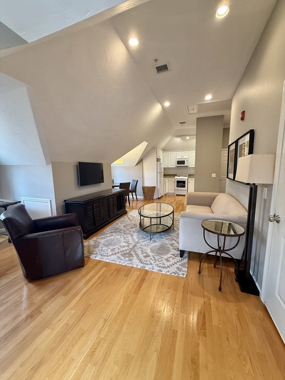 56 Eliot Street, Unit C Natick, MA 01760 - Photo 8 of 21 a living room with furniture and a wooden floor