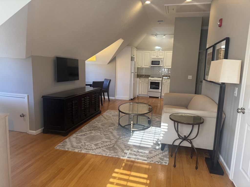 56 Eliot Street, Unit C Natick, MA 01760 - Photo 10 of 21 a living room with furniture and a flat screen tv