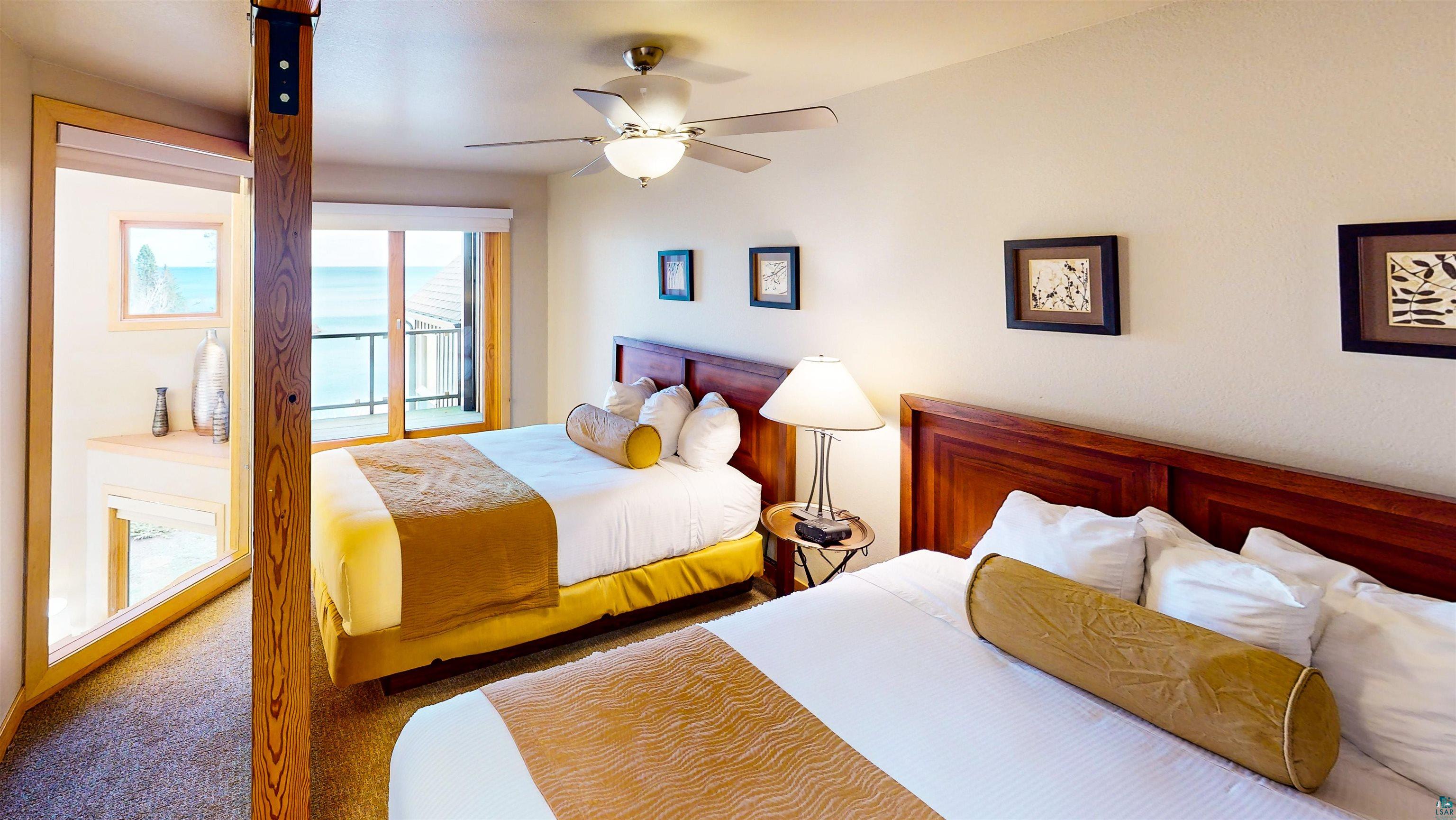 40 Surfside Drive, Unit 5D Tofte, MN 55615 - Photo 17 of 37 Spacious bedroom featuring wood-finish flooring, a ceiling fan with integrated lighting, and a private balcony with water views