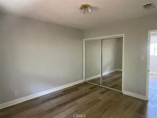 an empty room with wooden floor and door