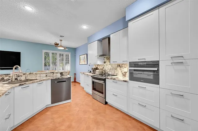 a kitchen with stainless steel appliances kitchen island granite countertop a sink and cabinets