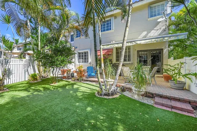 a view of a chair and table in backyard of the house