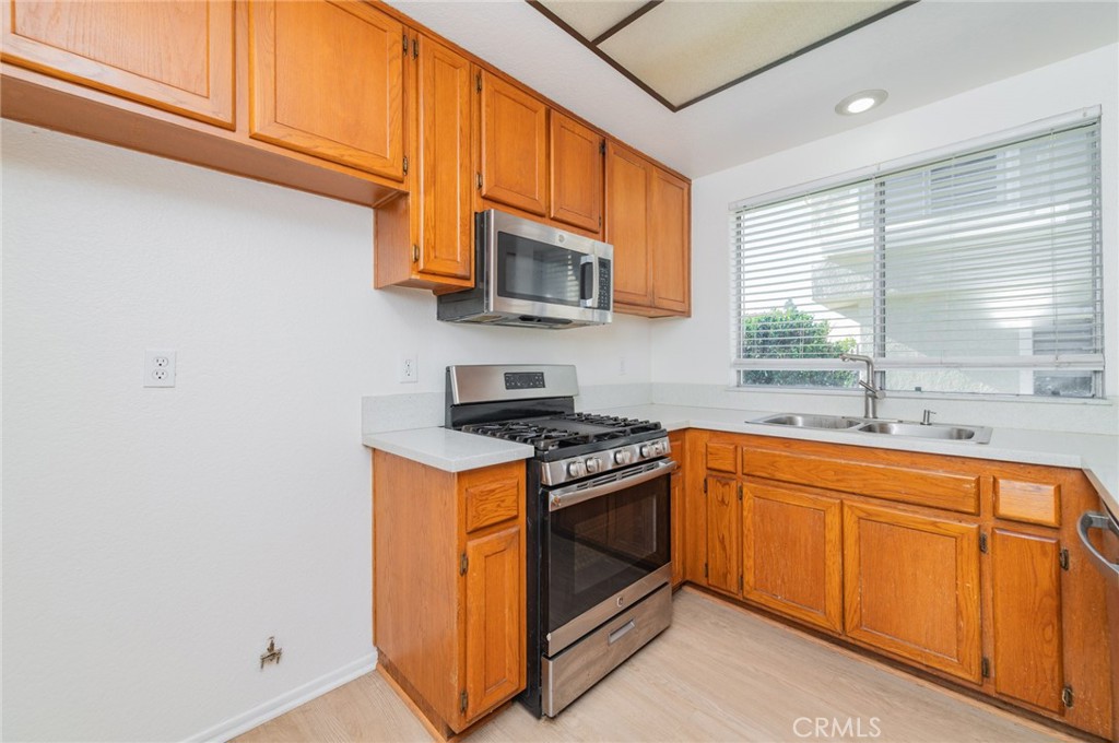 527 Springbrook North Irvine, CA 92614 - Photo 9 of 24 a kitchen with stainless steel appliances granite countertop a stove a sink and a microwave