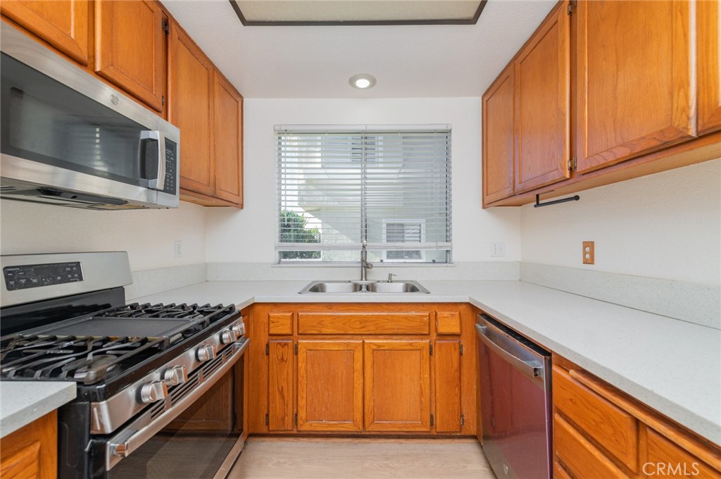 527 Springbrook North Irvine, CA 92614 - Photo 10 of 24 a kitchen with stainless steel appliances granite countertop a sink stove and microwave