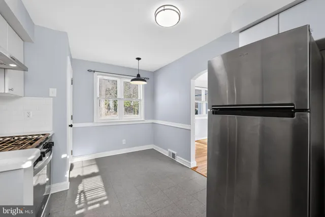 a view of kitchen with window and refrigerator