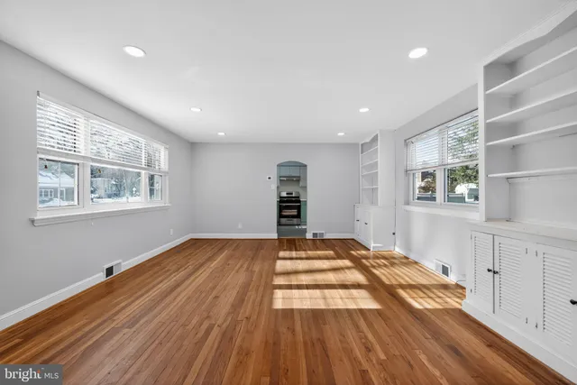a view of empty room with wooden floor and window