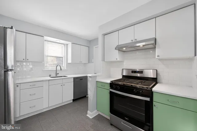 a kitchen with white cabinets and appliances