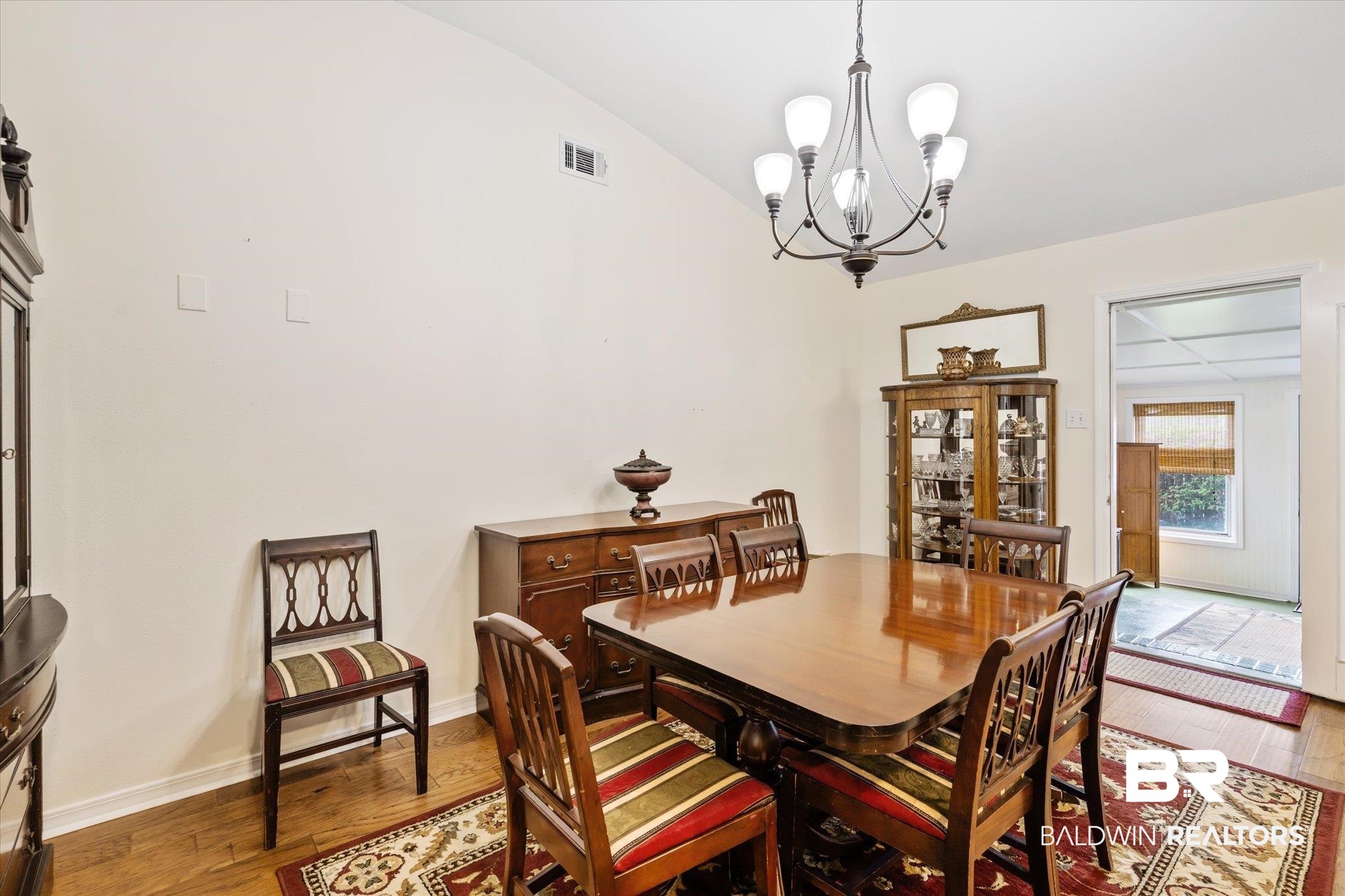 7236 Highpointe Place East Daphne, AL 36527 - Photo 7 of 32 Dining room featuring wood-type flooring, a notable chandelier, and vaulted ceiling
