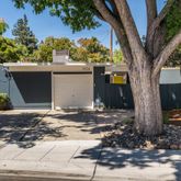 a view of a house with a tree in the background