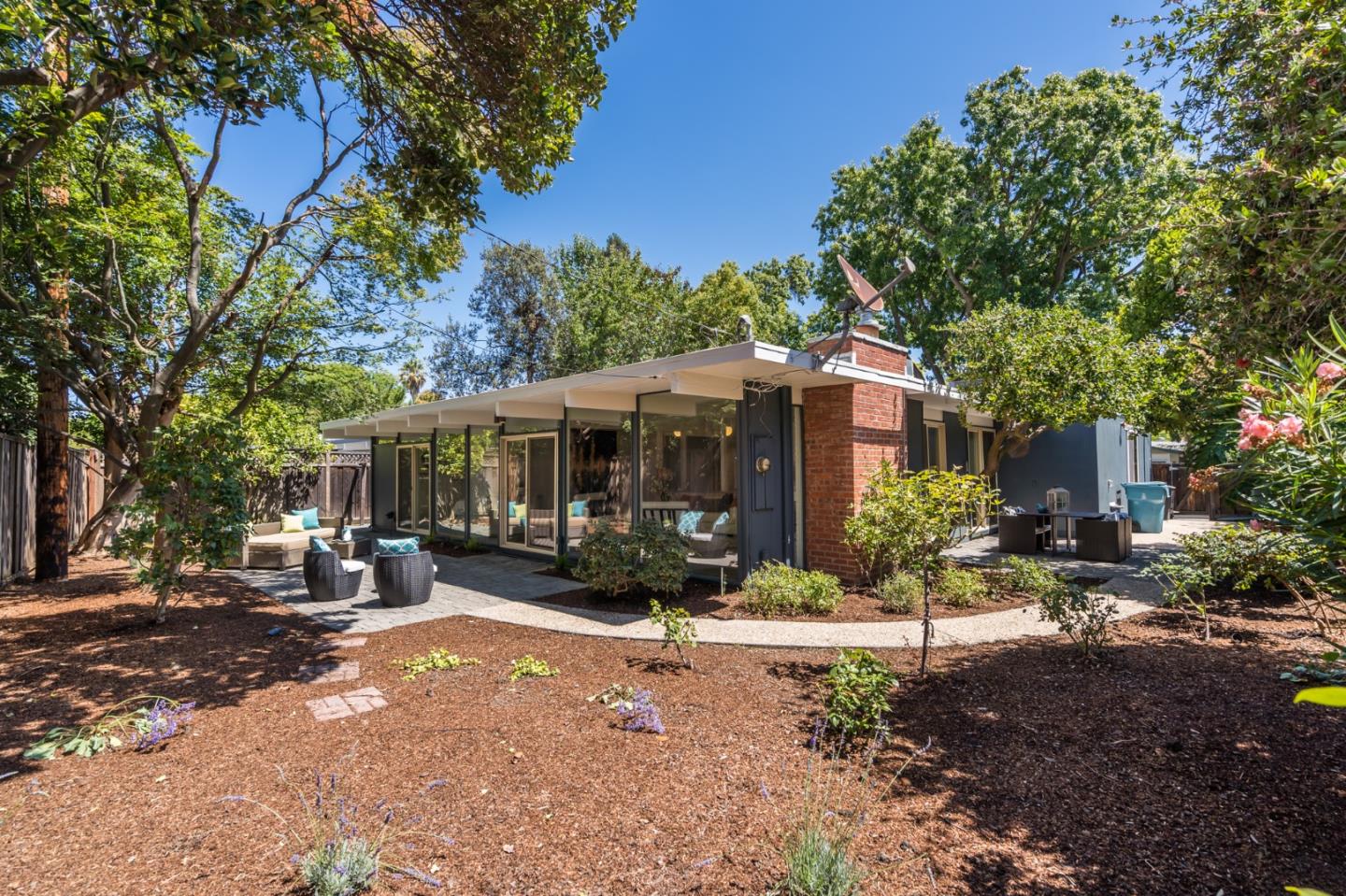 3924 Louis Road Palo Alto, CA 94303 - Photo 30 of 37 a view of a patio with table and chairs under an umbrella with large trees